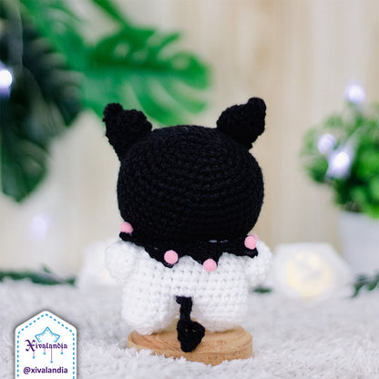 Peluche Kuromi de espaldas, con gorro en color negro. Mide 11 cm de alto, hecho a mano a crochet con estambre acrílico, ojos plásticos a presión y relleno sintético de poliéster. suave al tacto, ideal para coleccionar o decorar.