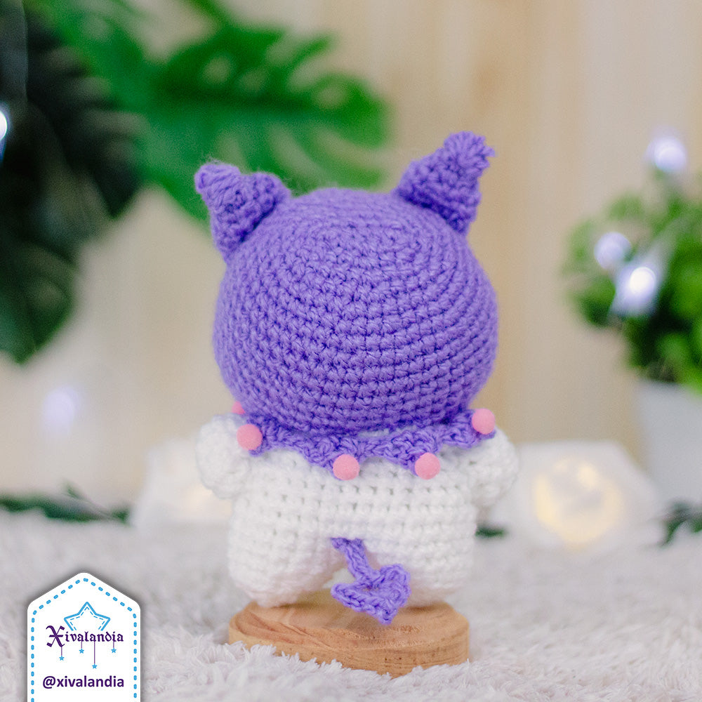 Peluche Kuromi de espaldas, con gorro en color lila. Mide 11 cm de alto, hecho a mano a crochet con estambre acrílico, ojos plásticos a presión y relleno sintético de poliéster. suave al tacto, ideal para coleccionar o decorar.